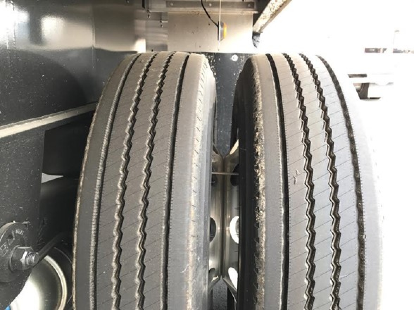 Dual rear trailer wheels and chassis of a Utility 4000Ae Combo Flatbed showing tire treads and frame components.