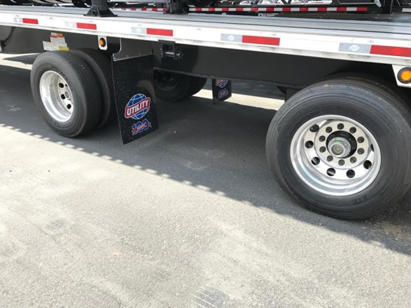 Utility 4000Ae combo flatbed trailer axle area showing dual rear tires and mud flaps with Utility logo