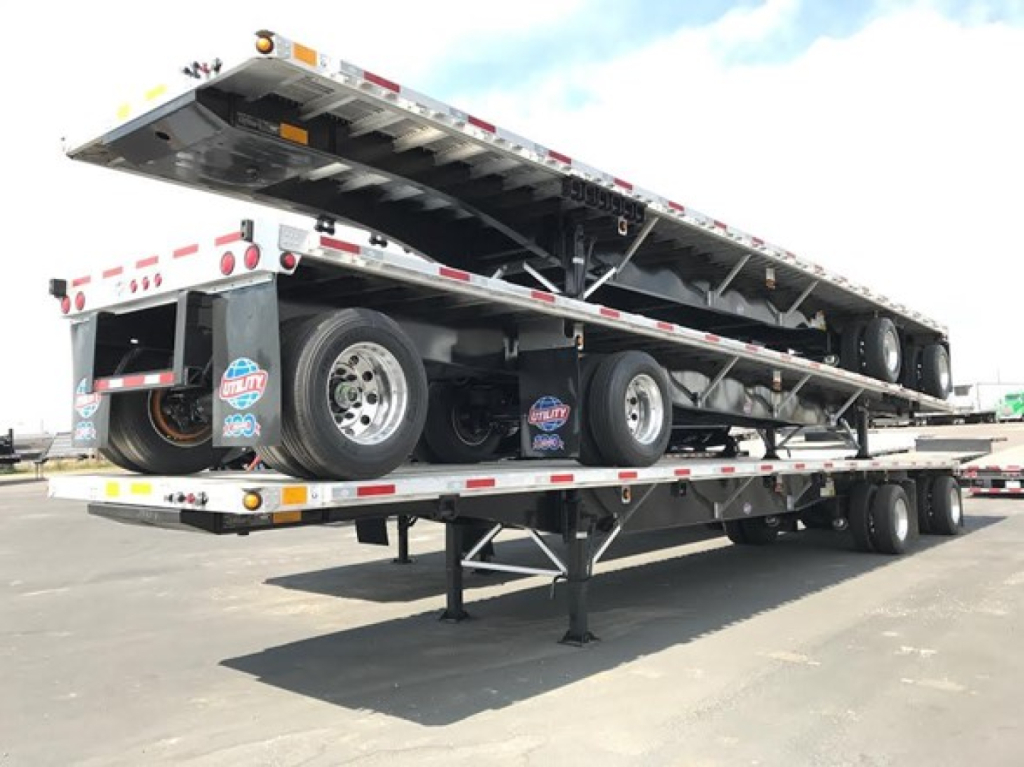 Utility 4000Ae Combo Flatbed trailer shown in raised position with dual rear axles and folded ramp; branding stickers on mud flaps; SN NE2529.