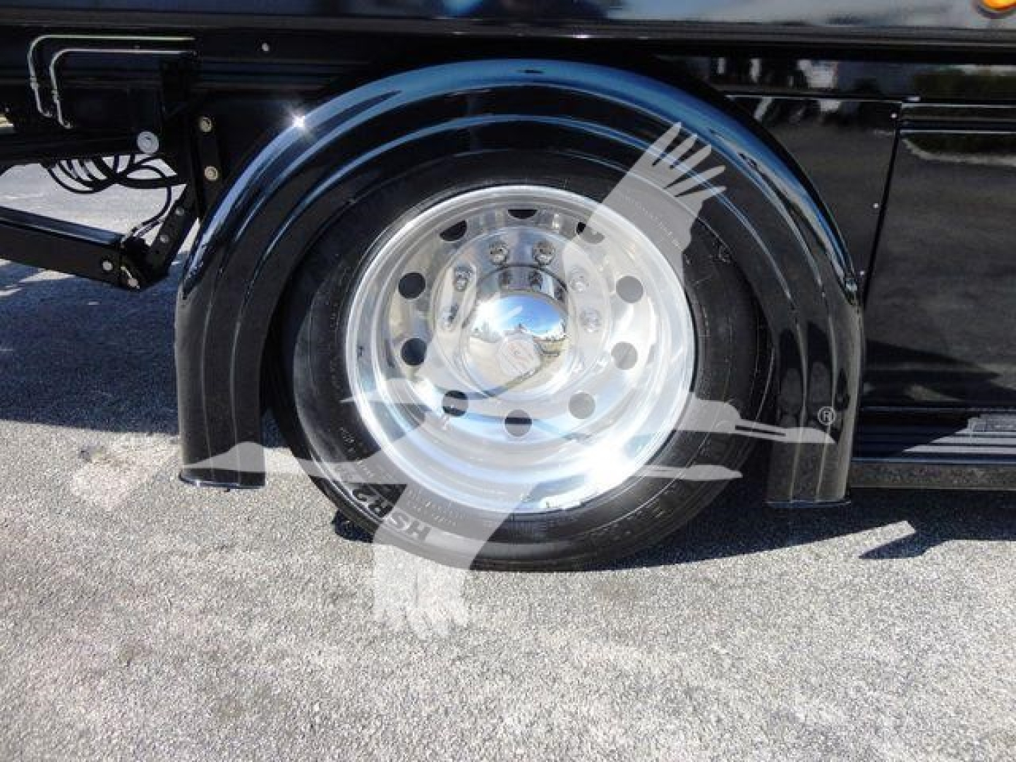 Truck wheel and fender showing polished steel wheel with black fender and reflection in hubcap.