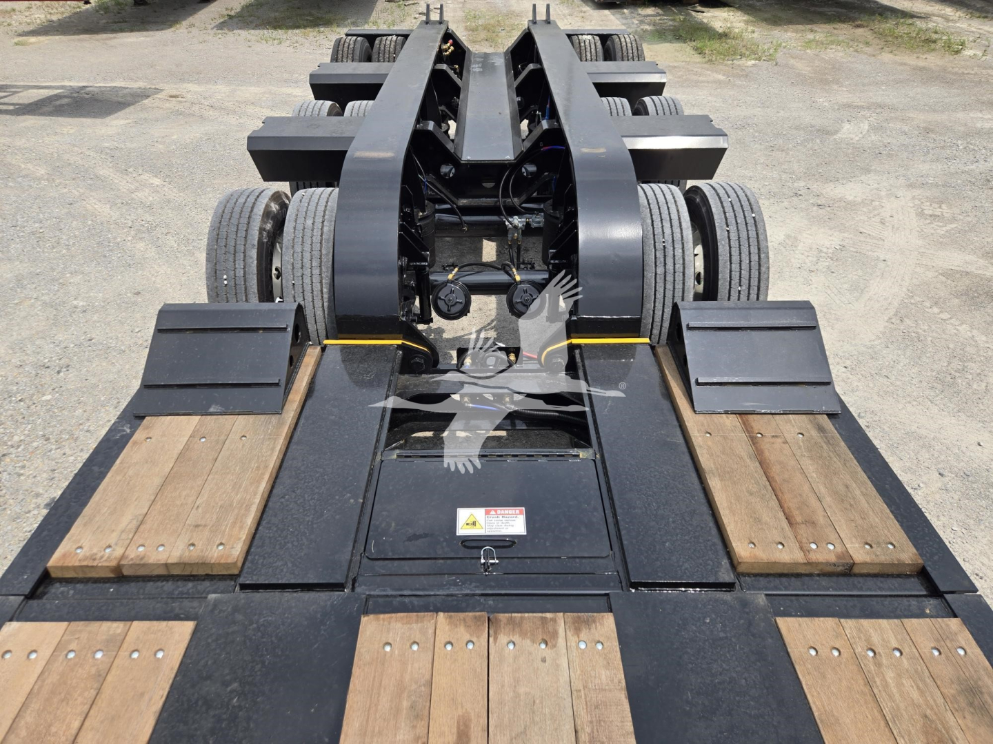 Fontaine 60HD MX lowboy trailer viewed from front with dual axles and wood deck sections.