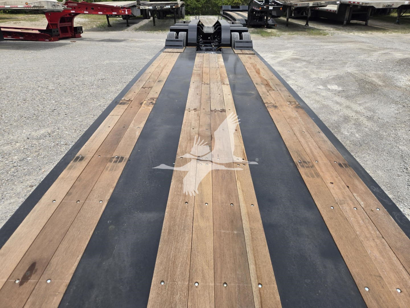 Trailer deck showing wooden planks with black center strip on Fontaine 60HD MX lowboy trailer, front connection hardware visible.