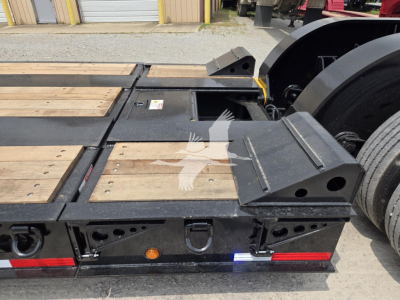 Fontaine 60Hd MX lowboy trailer rear deck with wooden planks, ramps, and bumper lights; visible VIN and stock info not on image; metal components and labels visible.