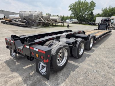 Trailer rear view showing Fontaine 60HD MX lowboy trailer with triple axle and long flatbed. Visible are rear lights, fenders, and large reels/spools on the side.