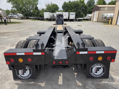 Trailer rear view showing 60ft lowboy with dual axle and heavy-duty frame, taillights, mudflaps with Fontaine Specialties logo, and rear bumper with reflectors.