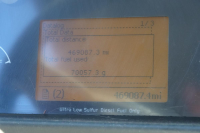 Vehicle instrument display showing total distance 469,087.3 miles and total fuel used 70,057.3 gal with Ultra Low Sulfur Diesel Only label.
