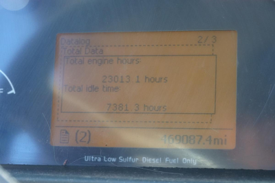 Digital dashboard display showing total engine hours 2303.1 hours and total idle time 7381.3 hours, with odometer 469087.4 miles; Ultra Low Sulfur Diesel Fuel Only label visible.