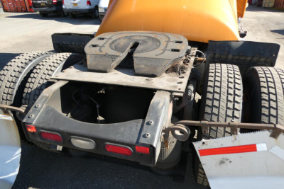Tractor-trailer rear view showing fifth wheel mount and dual rear tires on a Volvo VNM42T daycab.