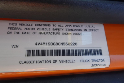Label on orange truck part showing VIN 4V4M19DG8CN550228 and barcode, with text 'THIS VEHICLE CONFORMS TO ALL APPLICABLE U.S.A. FEDERAL MOTOR VEHOR SAFETY STANDARDS IN EFFECT ON THE DATE OF MANUFACTURE SHOWN ABOVE.' VIN 4V4M19DG8CN550228 CL