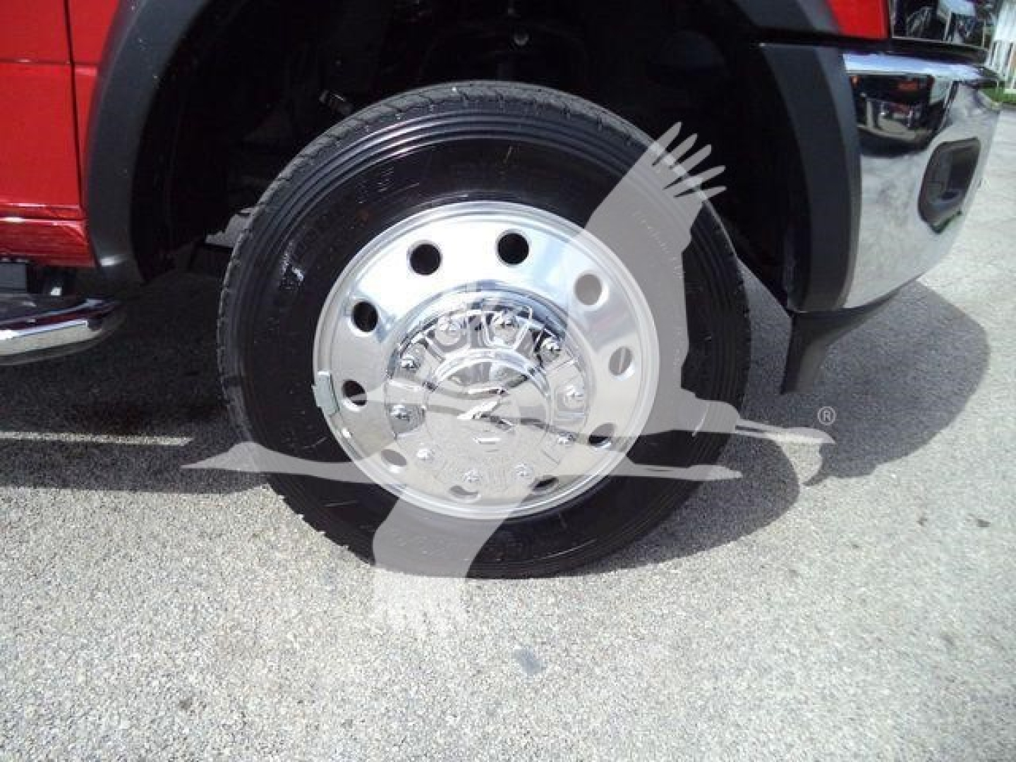 Ram 5500 front wheel showing steel rim and tire with red fender and chrome bumper in-service view