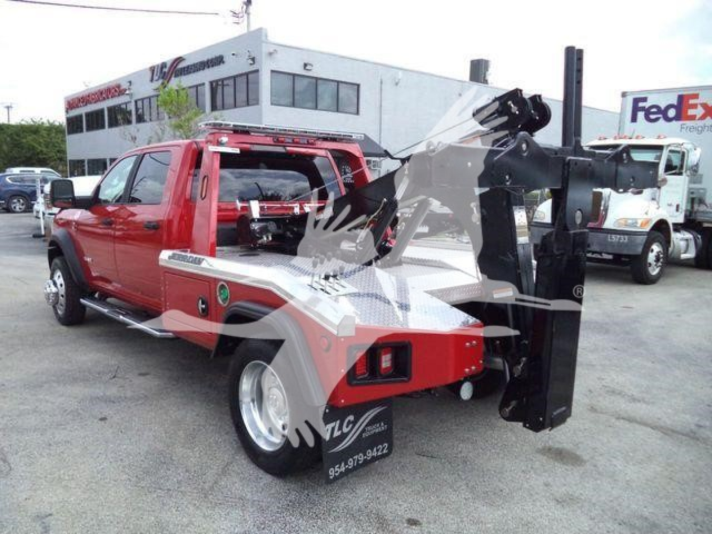 Ram 5500 tow truck with crane attachment in a showroom lot. Visible text on equipment includes Winch category and MPL40RAM5500RED stock number.