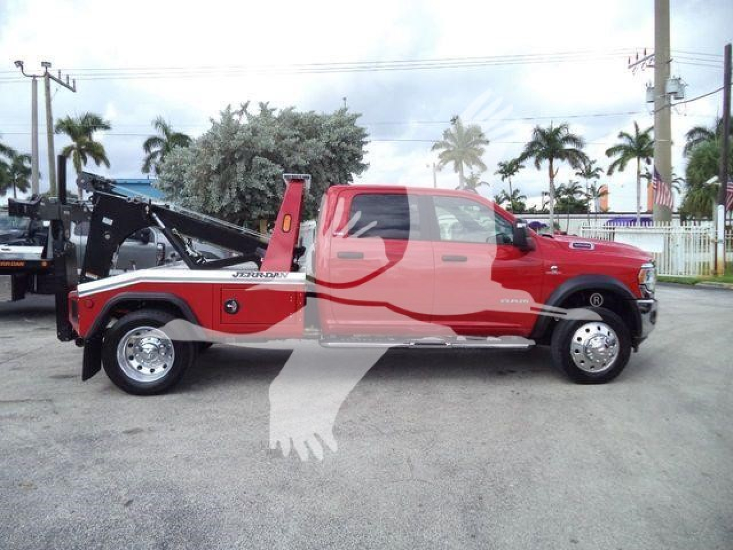 Ram 5500 tow truck side view showing winch equipment and red cab with black accents.