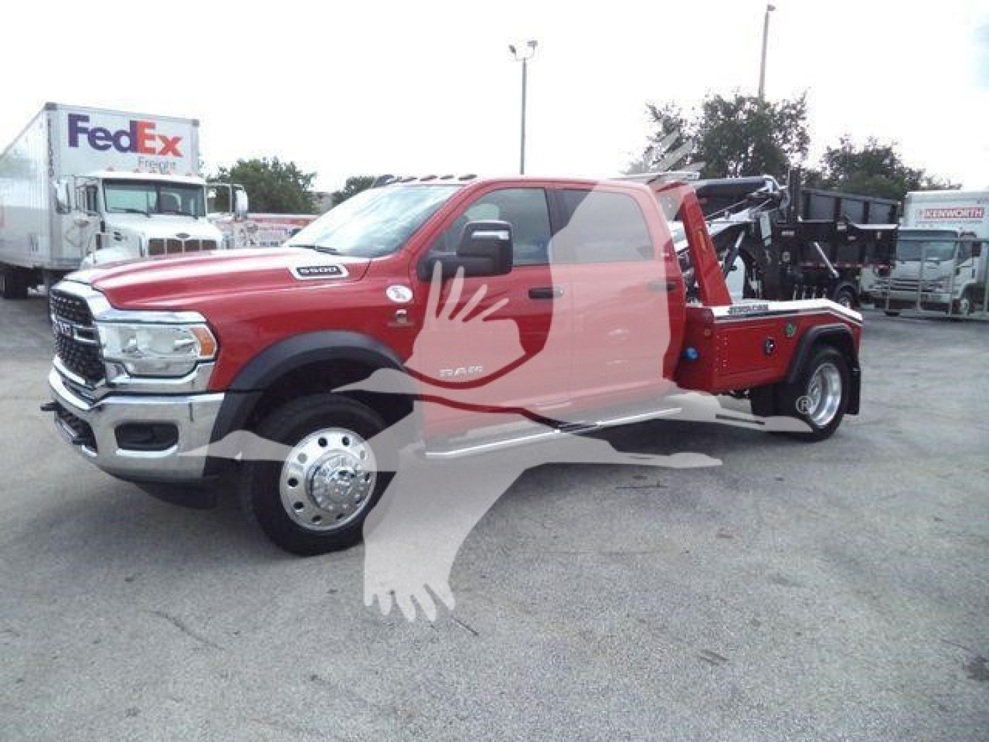 Ram 5500 tow truck/winch setup showing front grille, dual rear wheels, and red service body with black winch equipment in bed.