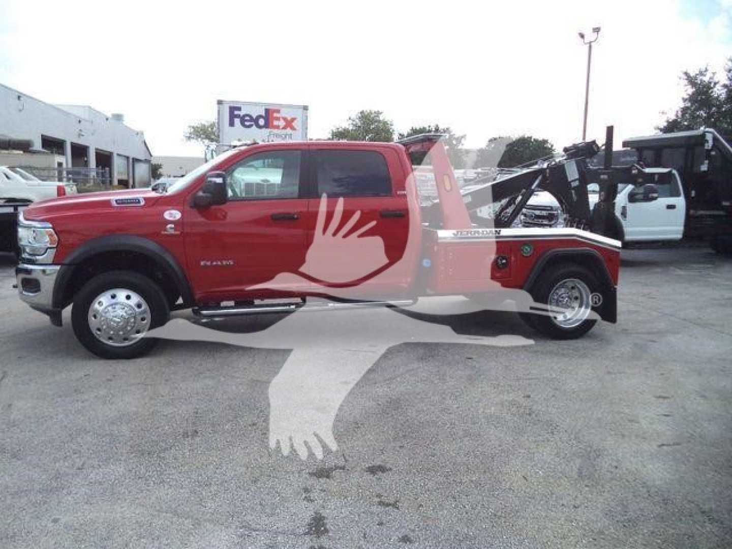 Ram 5500 truck with winch in bed, red exterior, side view showing front grille, wheel, and hoop-style rear winch apparatus.