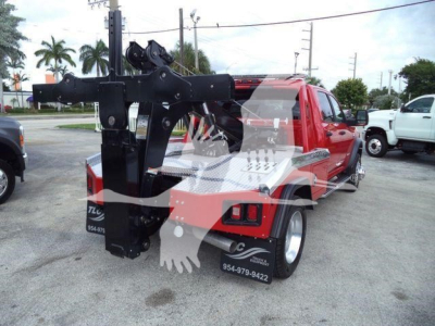Ram 5500 SLT truck with heavy-duty winch crane attachment mounted in rear bed, red cab, black tool/aluminum bed surface and safety decals