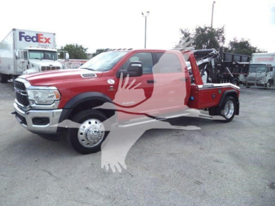 Ram 5500 tow truck/winch setup showing front grille, dual rear wheels, and red service body with black winch equipment in bed.