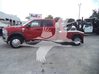 Ram 5500 truck with winch in bed, red exterior, side view showing front grille, wheel, and hoop-style rear winch apparatus.