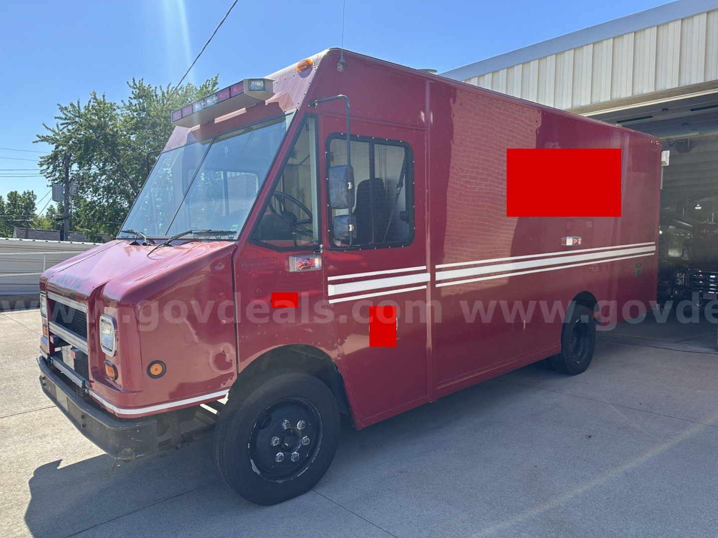 Freightliner MT45 chassis cab showing red exterior and white roof details with side stripe; visible front grille and wheel.