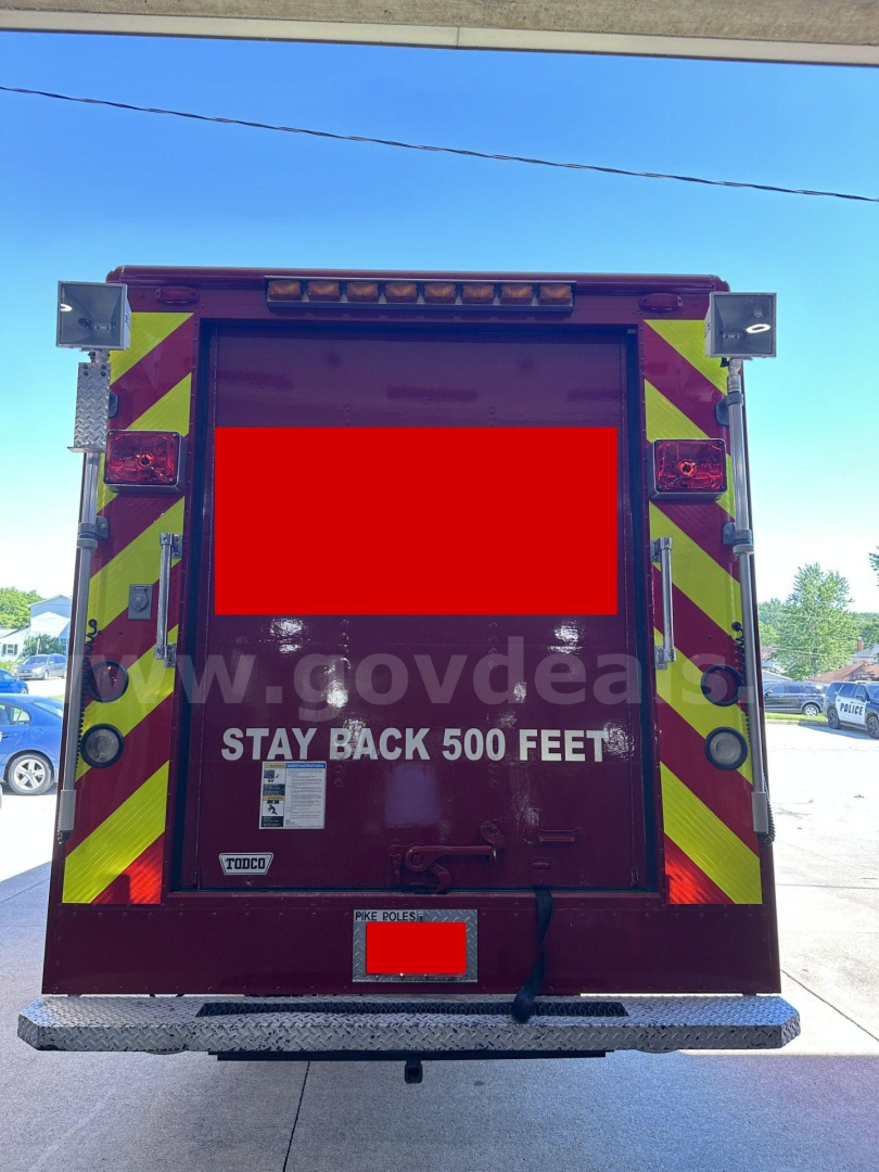 Rear view of a red Freightliner MT45 cab and chassis with high-visibility chevrons, doors closed, text 'STAY BACK 500 FEET' visible on the rear hatch, license area obscured.
