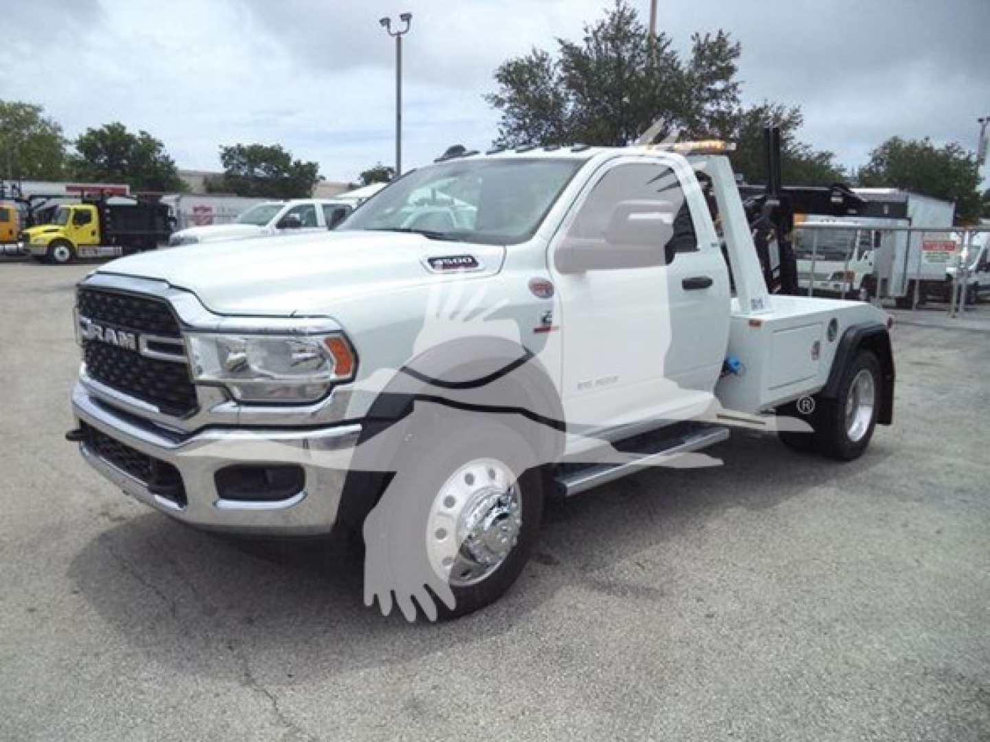 Ram 3500 tow truck with winch, white cab and flatbed, chrome grille, large side mirrors, on lot