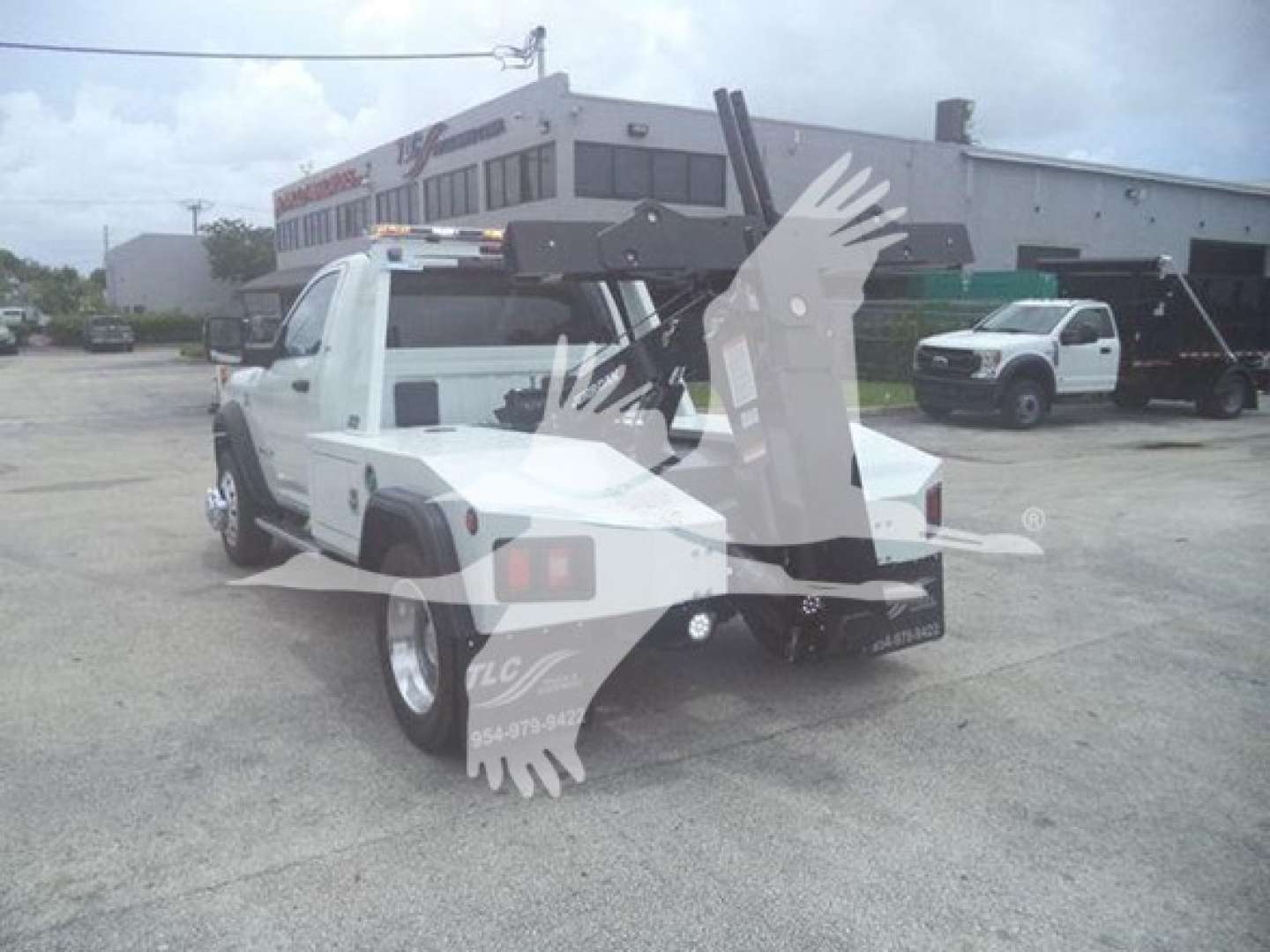 Truck bed with winch equipment attached, Ram pickup with towing apparatus visible in a dealership lot.