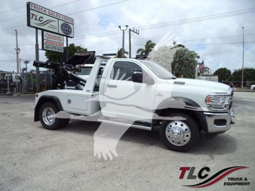 Ram 2500 tow truck with winch system on flatbed, white crew cab, side view, TLC dealership background.