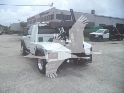 Truck bed with winch equipment attached, Ram pickup with towing apparatus visible in a dealership lot.