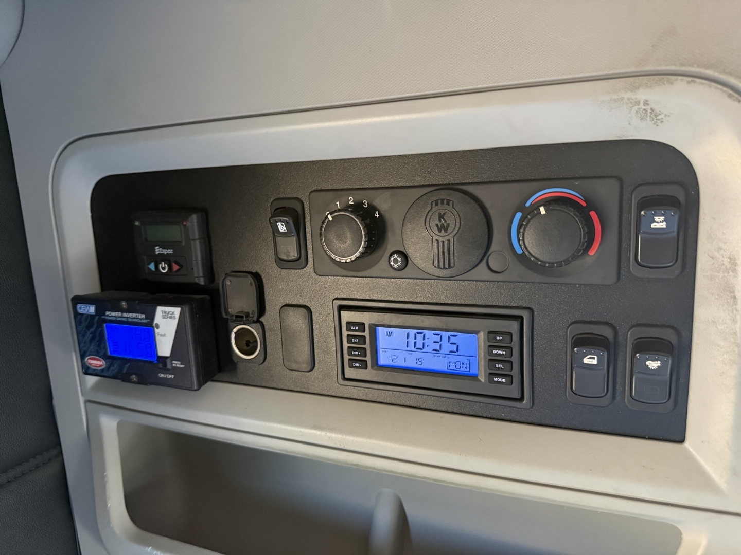 Kenworth T680 dash panel showing climate controls, radio, and auxiliary switches. Visible text includes clock reading 10:35 and various control labels.