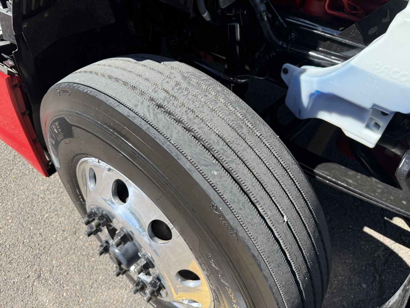 Kenworth T680 front wheel/view showing tire tread and wheel hub.
