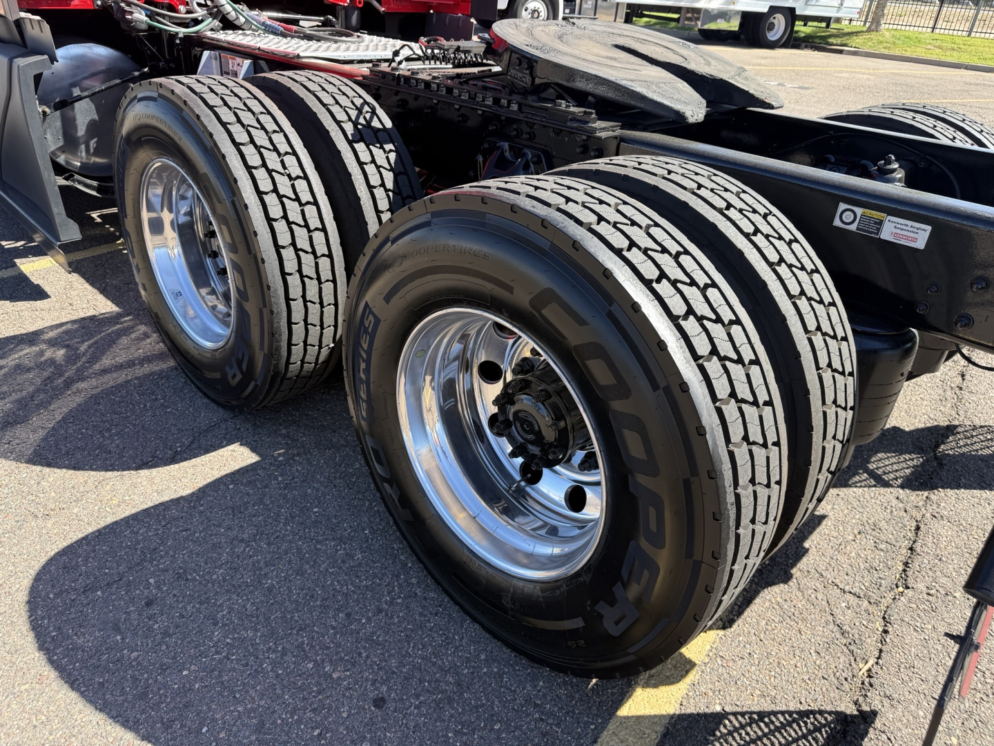 Dual rear tractor tires on a Kenworth truck chassis, chrome rims, tread pattern visible.