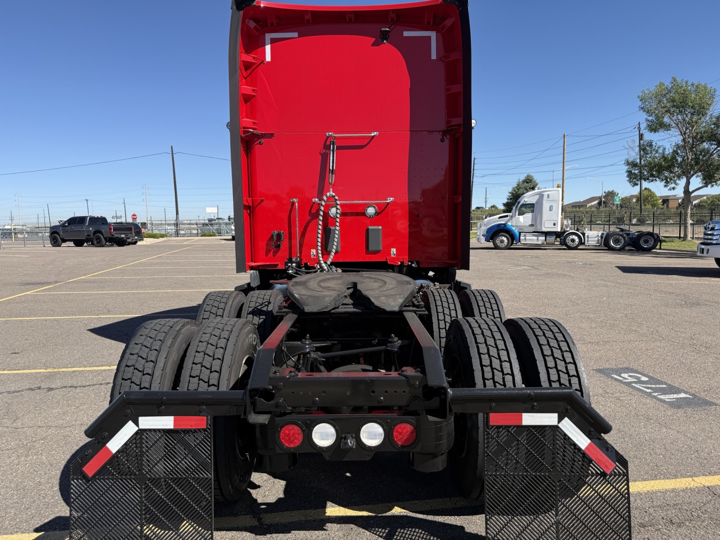 Kenworth T680 rear view showing fifth wheel and dual rear axles in a parking lot.