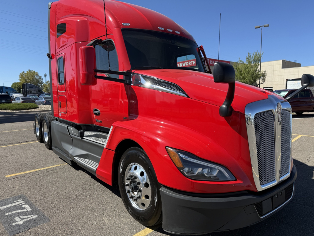 Kenworth T680 Class 8 truck, red cab, front three-quarter view showing chrome grille, headlamp cluster, and black bumper.