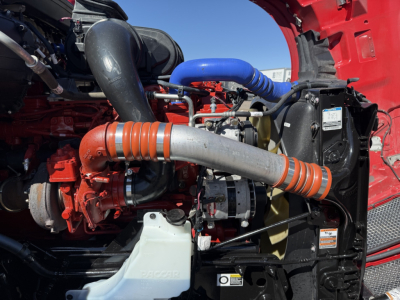 Kenworth T680 engine bay showing turbocharger and intercooler pipes and blue radiator hose
