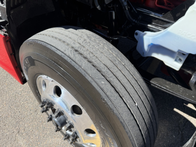 Kenworth T680 front wheel/view showing tire tread and wheel hub.