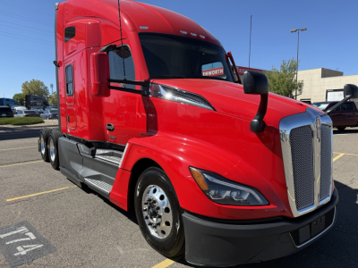 Kenworth T680 Class 8 truck, red cab, front three-quarter view showing chrome grille, headlamp cluster, and black bumper.