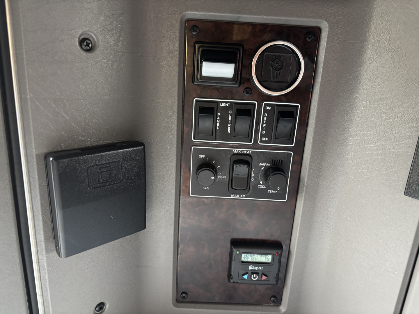 Kenworth W900L dash panel showing switches and gauges with a small digital meter and a black rectangular enclosure.