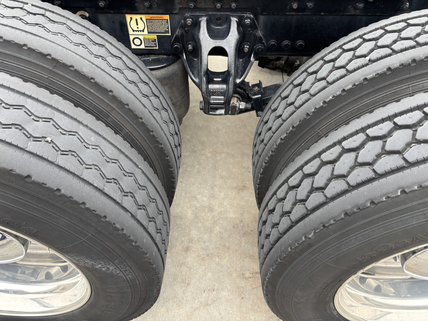 Kenworth W900L rear dual tires and suspension view showing trailer hitch area and twin rear axles.