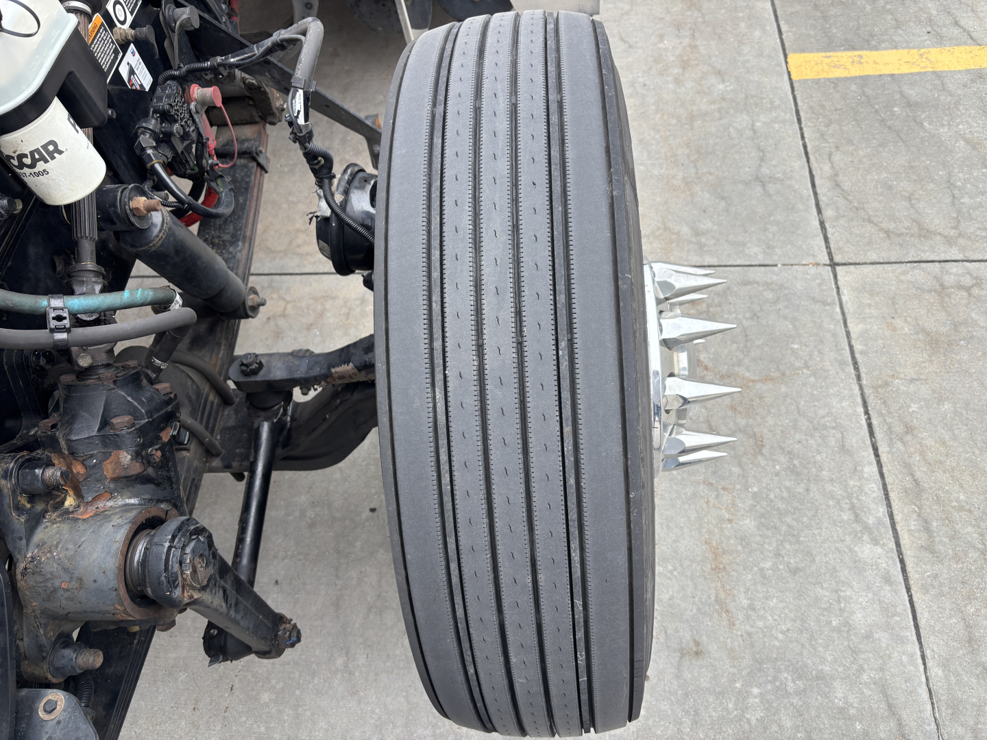 Kenworth W900L truck front wheel with dual steer/drive setup and exposed components