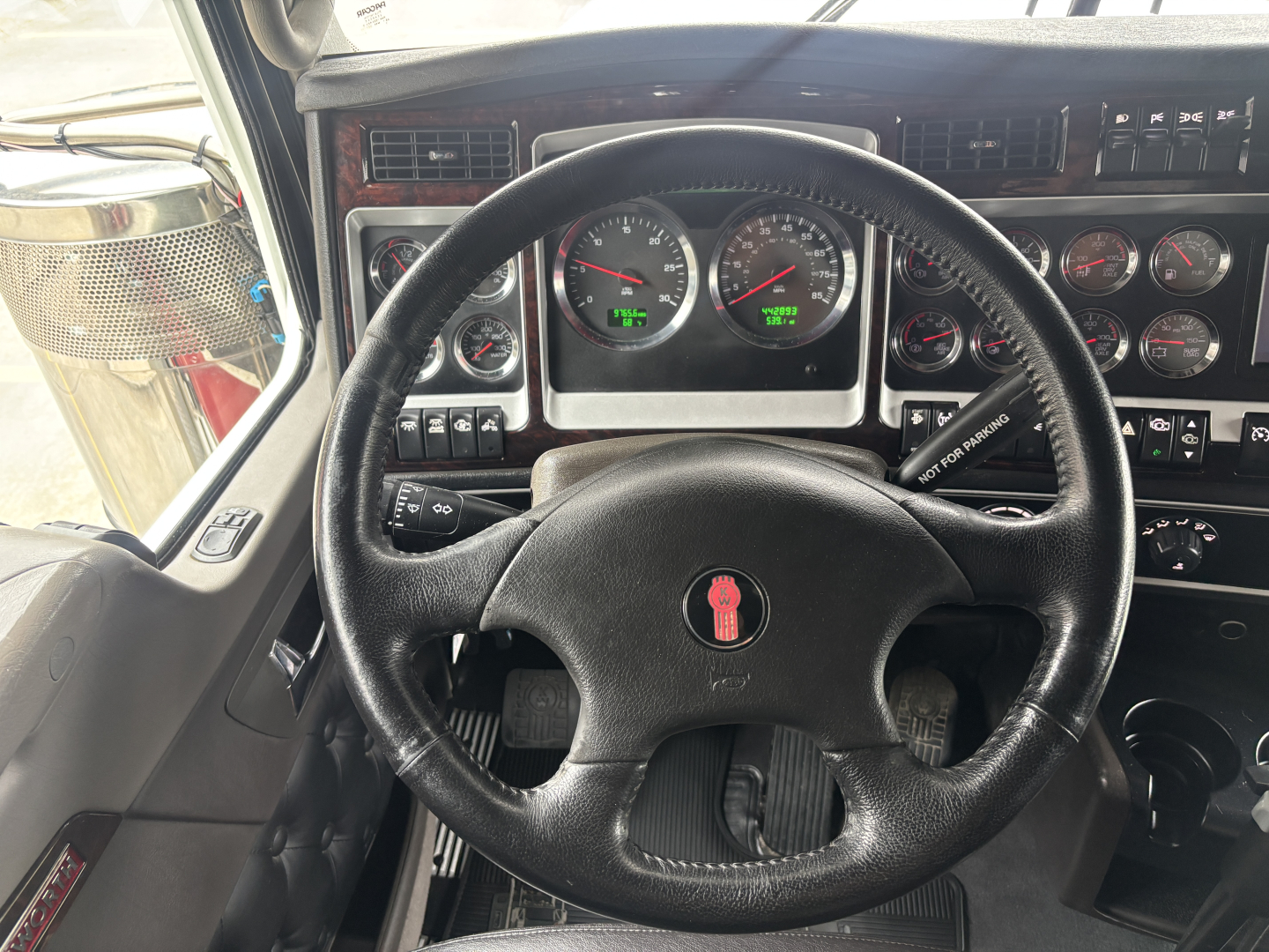 Kenworth W900L truck interior dashboard with steering wheel and gauges visible.