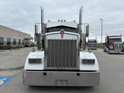 Kenworth W900L front view showing tall vertical exhaust stacks and large chrome grille. No license plates visible.