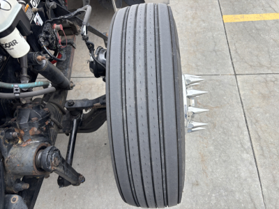 Kenworth W900L truck front wheel with dual steer/drive setup and exposed components
