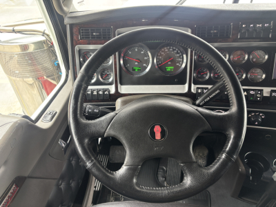 Kenworth W900L truck interior dashboard with steering wheel and gauges visible.