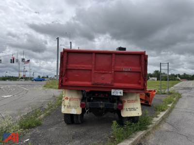 Dump truck bed and rear view showing plow mount, tailgate with Hell label, and dual rear wheels with mud flaps.
