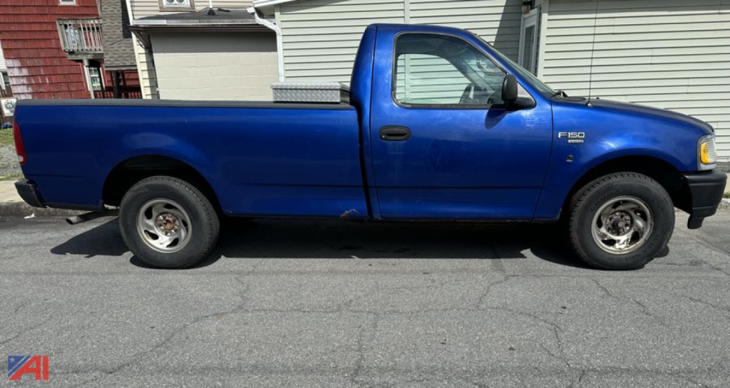 Blue 1998 Ford F-150 regular cab long bed pickup truck side view with single cab, two-wheel drive, plain steel wheels, and tonneau cover over bed.