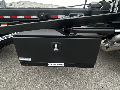 Volvo VHD64B300 rolloff truck side view showing a black Albreath toolbox mounted underframe with key lock and hydraulic lines.
