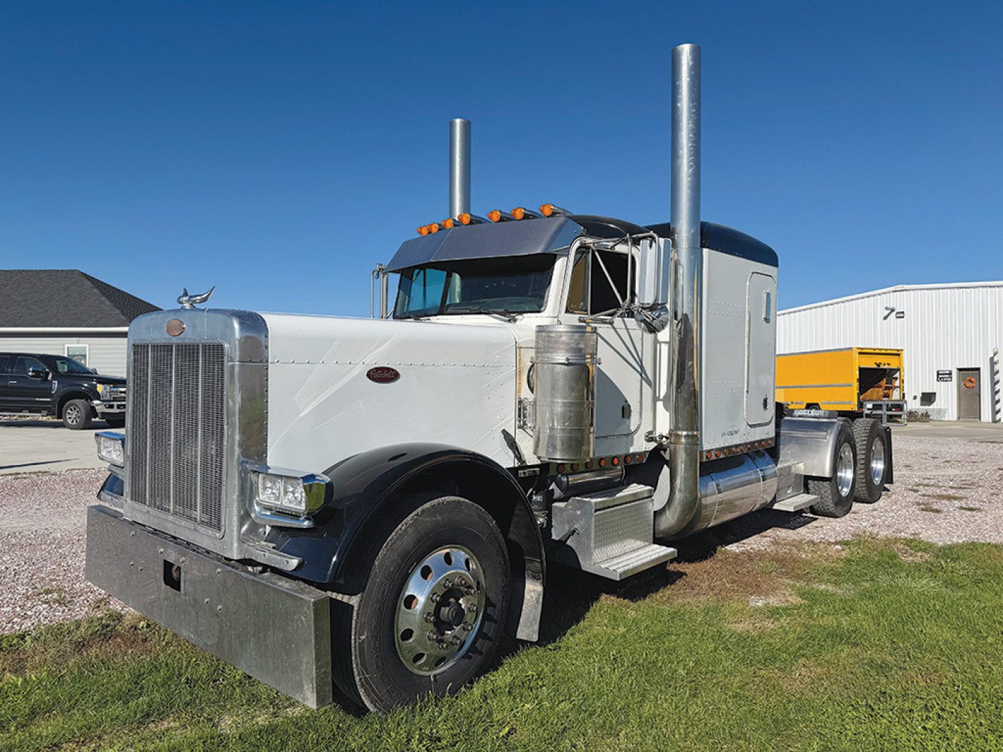 Peterbilt 379 long-nose truck from side view showing chrome exhaust stacks and sleeper cab.
