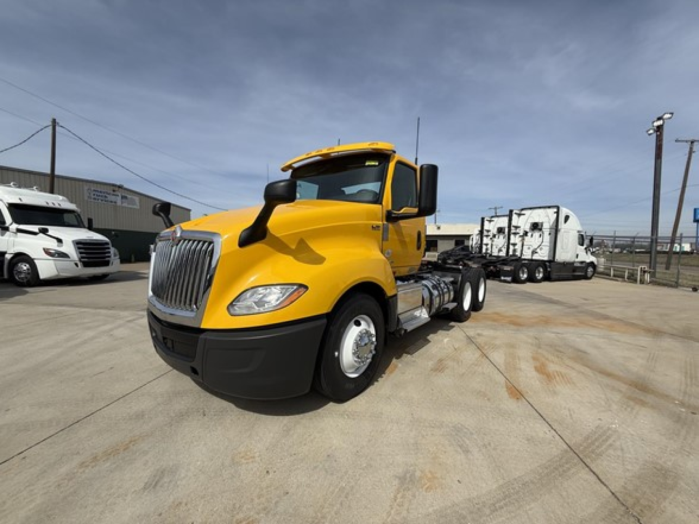 2019 International LT625 daycab truck with yellow cab and black bumper, front three-quarter view