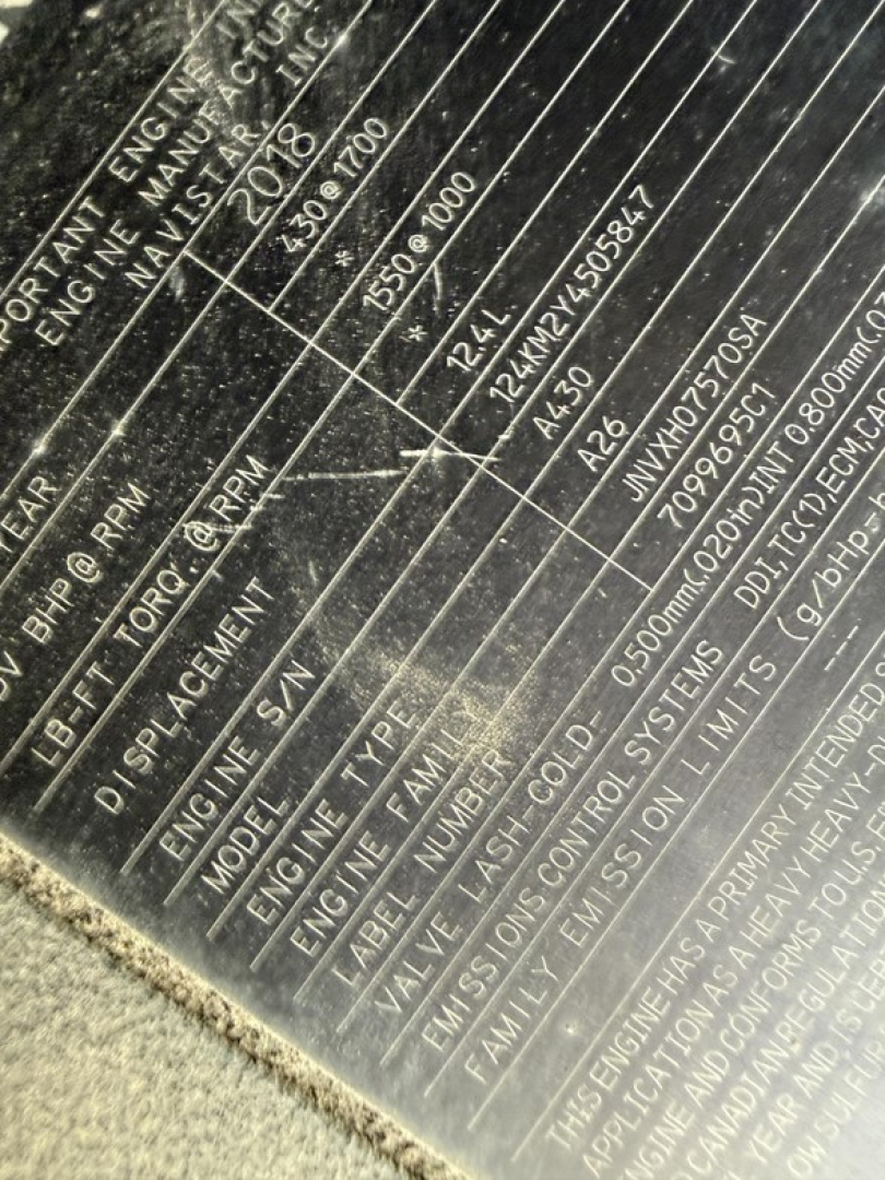Engine/vehicle data plate showing serials and specs for a 2019 International LT625. Visible text includes VIN partials, engine RPM ranges, and measurement lines, though some fields are scratched.