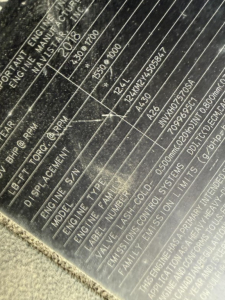 Engine/vehicle data plate showing serials and specs for a 2019 International LT625. Visible text includes VIN partials, engine RPM ranges, and measurement lines, though some fields are scratched.