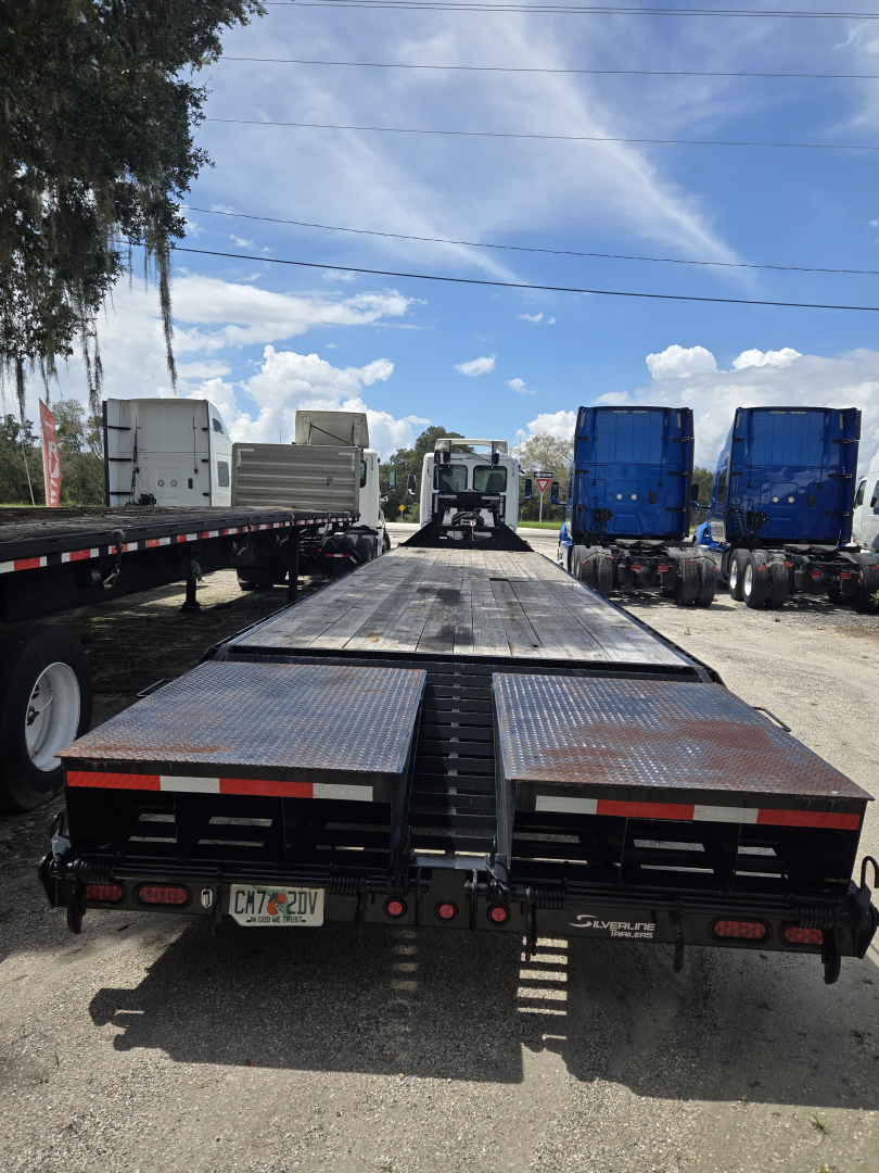 40 ft East Gooseneck flatbed trailer with ramps and dual rear ramps, viewed from the rear showing metal deck and wheel wells.